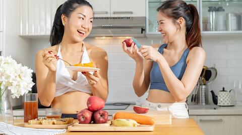 2 Mädchen lachen und genießen ein paar gesunde Snacks