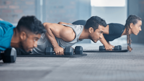 Drei Personen bei Übungen mit Gewichten