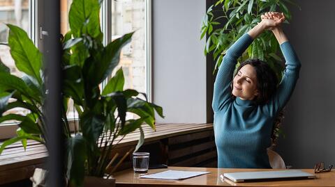 Eine Frau übt Yoga und Stretching gegen Burnout