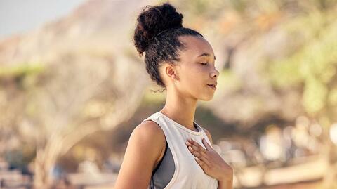 Frau im Yoga-Outfit mit geschlossenen Augen