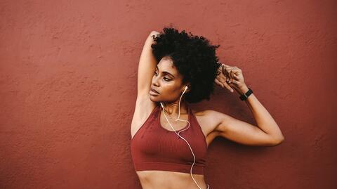 Junge Frau im roten Sport-BH beim Stretching