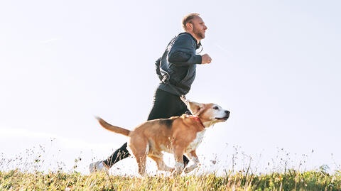 Ein Mann joggt mit seinem Hund und betont, wie wichtig es ist, sich im Freien aufzuhalten