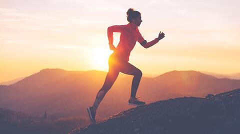 Eine Frau, die einen Berg hinaufläuft, symbolisiert Selbstfürsorge